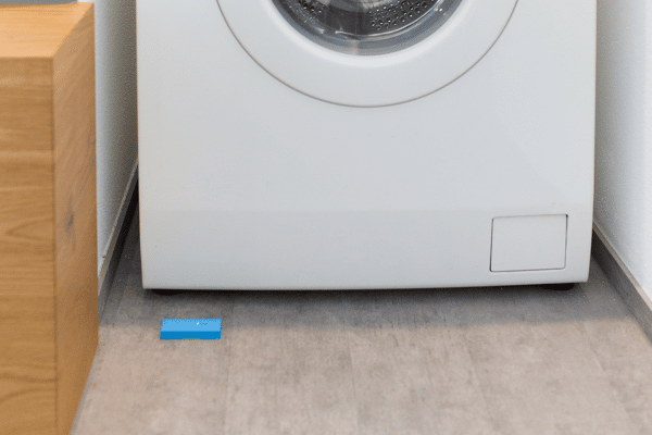 Wassermelder im Einsatz unter einer Waschmaschine